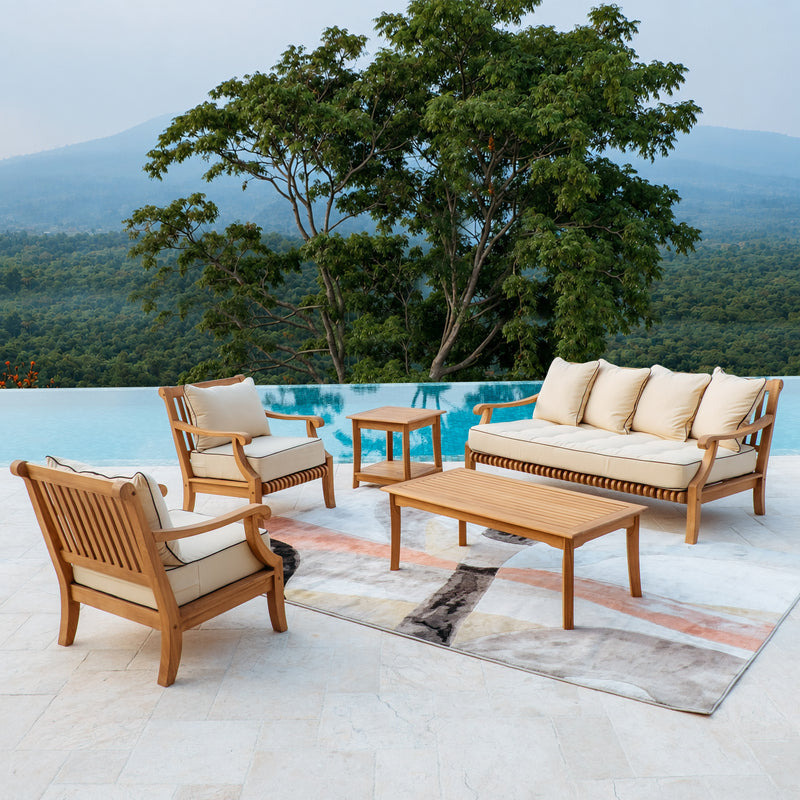 A 5-piece outdoor teak patio conversation set made of light brown teak wood with taupe cushions, arranged on a patterned rug next to a swimming pool with a forest background.