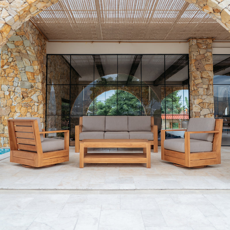 Outdoor patio furniture set with wooden chairs and sofa against a stone wall.