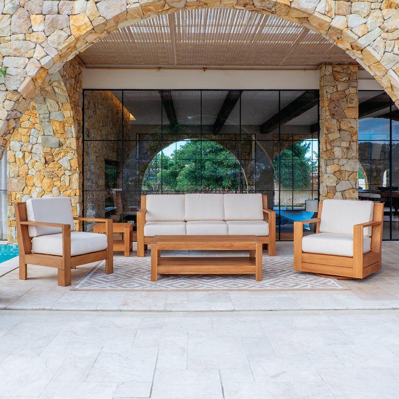 Outdoor patio furniture set with wooden frames and white cushions in a stone archway setting.